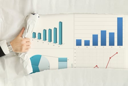 A person’s hand rips back a paper cover to reveal a series of charts