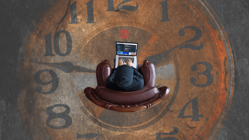 Man sitting using AI software on computer with clock drawn on ground