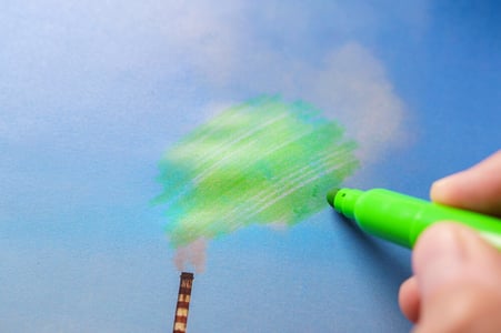 man painting green pollution chimney